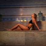 A woman soaking up the the heat of a sauna in Spa 1877