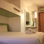 Interior of a bedroom featuring a double bed with a single bunk bed above and modern décor.