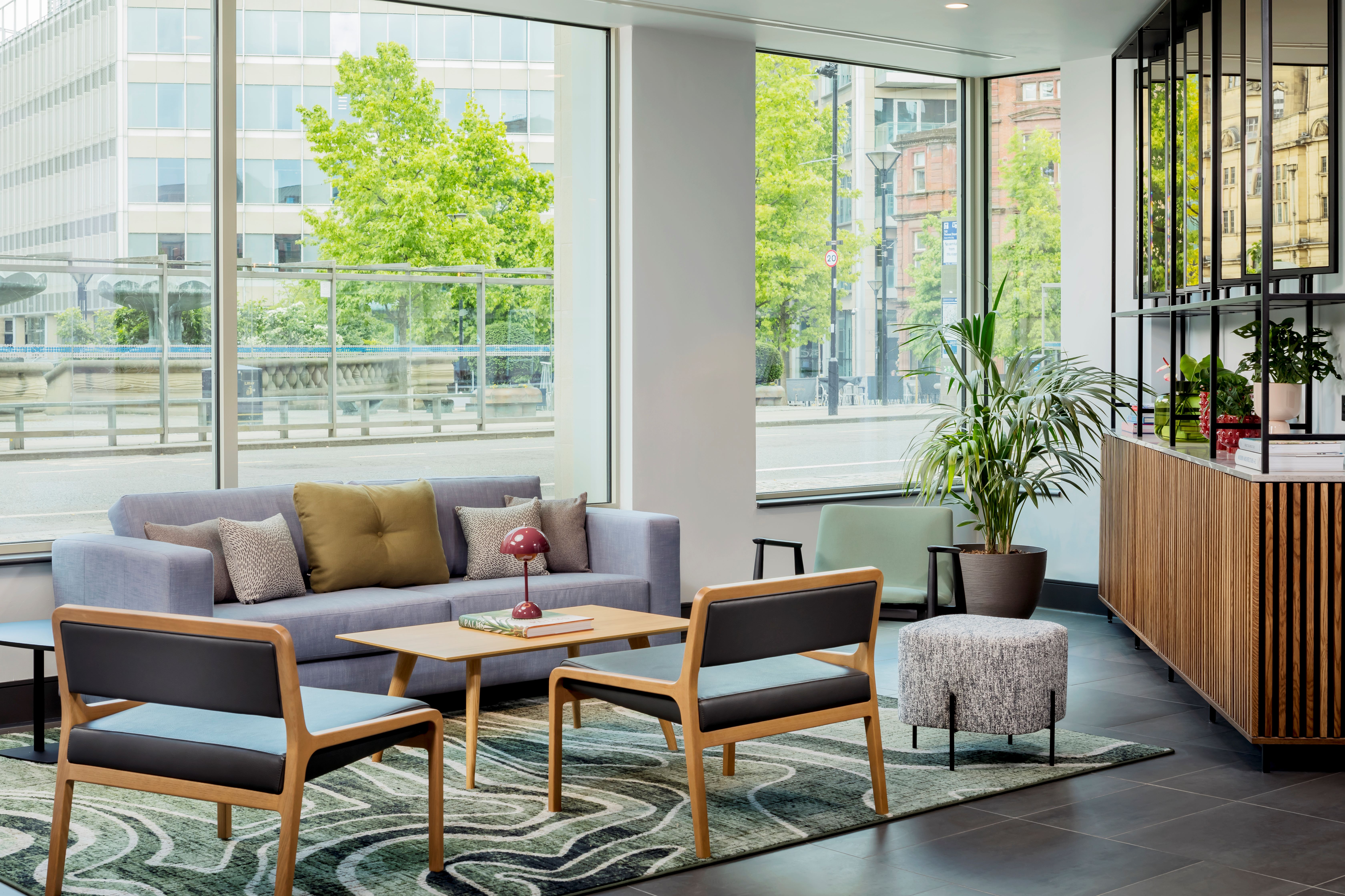 Reception area with a sofa facing a large window overlooking the outside.