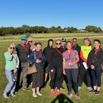 A group of people standing in a grassy field.