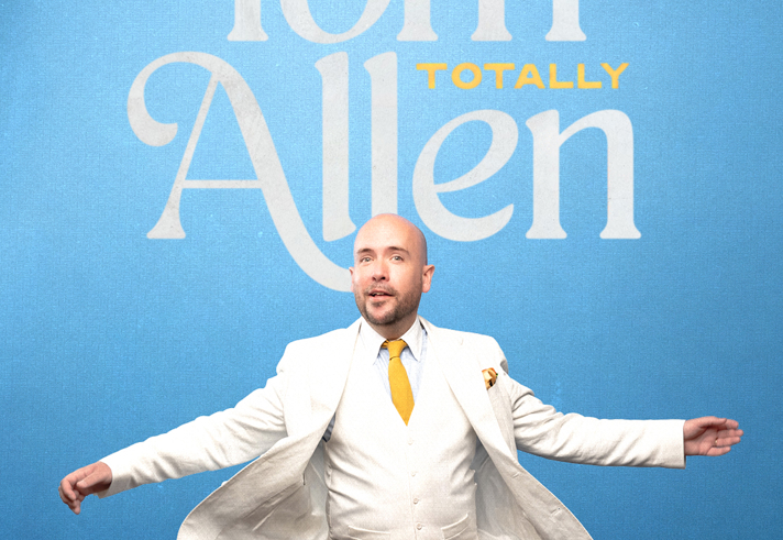 Poster for the show with Tom Allen in a white three piece suit.