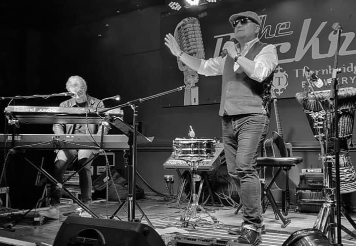 Black and white picture of musicians performing om stage.