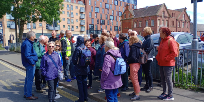 A tour guide talks to a group of people on a tour in Sheffield.