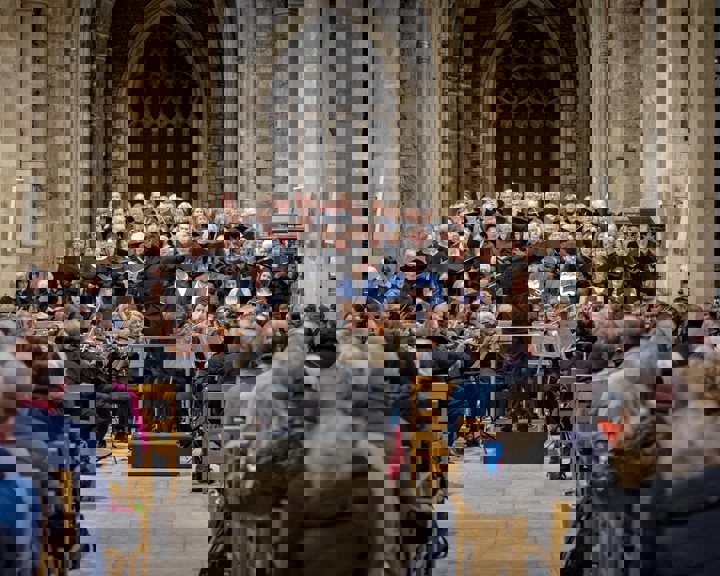 A large choir sing in Sheffield Cathedral in front of a large seated audience.