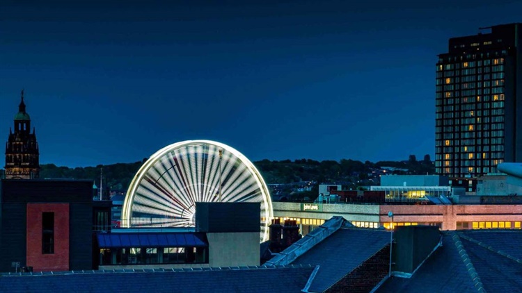 The Sheffield skyline at night, with a ferris wheel in the middle of the image.
