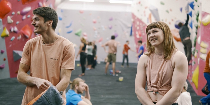 People having fun at an indoors climbing wall.