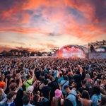 Crowd in front of the Bassfest stage from a previous year, as the sun goes down.