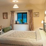 Loadbrook Cottage – double bedroom decorated in cream tones with bed and bedside tables.