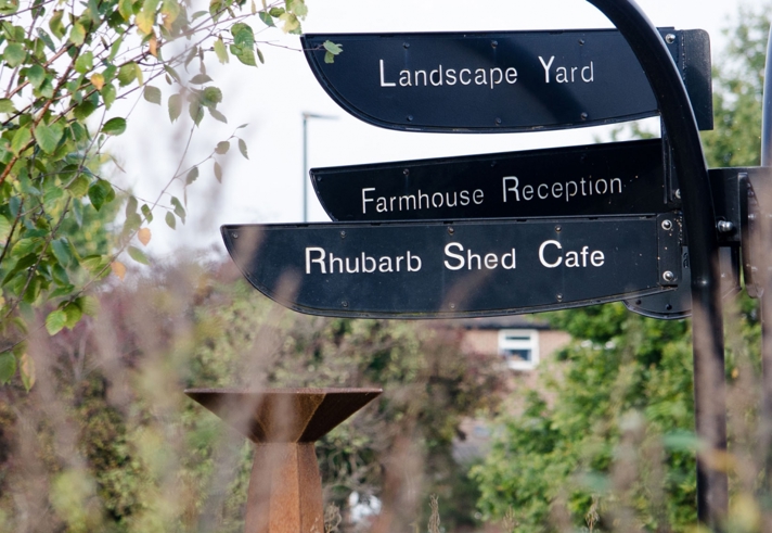 A signpost at Manor Lodge Sheffield, one of which read Rhubarb Shed Cafe.