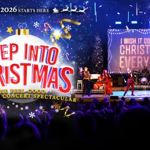 Promotional image for a Christmas concert featuring a festive stage performance and audience. On the left, colourful text reads “Step Into Christmas – The Feel Good Christmas Concert Spectacular” beneath the slogan “Your Christmas 2026 Starts Here”. On the right, performers sing on a brightly lit stage with a large screen displaying “I Wish It Could Be Christmas Everyday”. The design uses Christmas decorations, stars, ribbons and sparkling blue lighting.