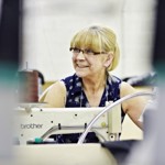 A woman sat at an industrial sewing machine.
