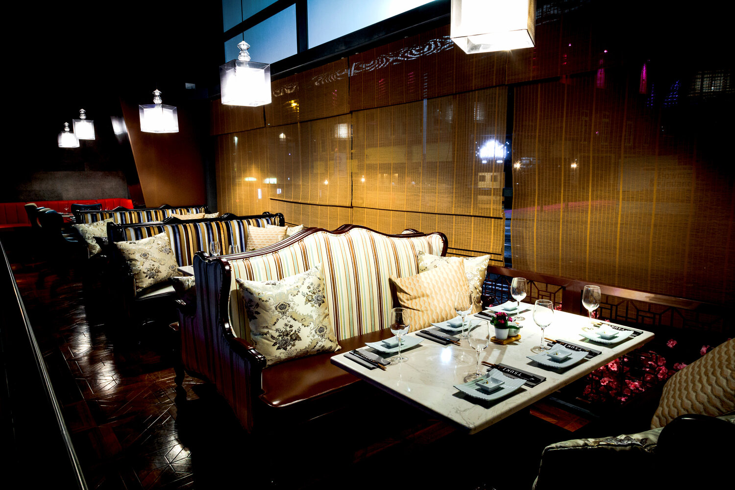 The interior of Tsuki, with a row of 4 tables in booths with subdued lighting.