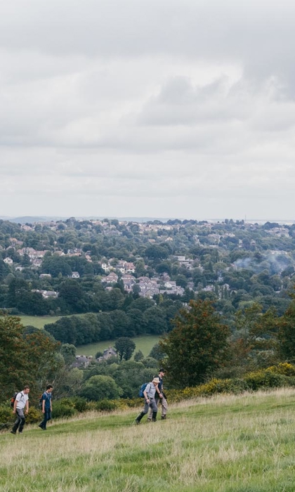 A group of people walk up a hill, at an event that is part of the Sheffield Walking Festival.