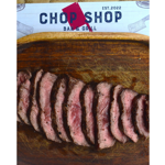 Overhead view of sliced medium-rare steak arranged on a well-used wooden chopping board. The meat has a seared outer crust and pink centre, with juices visible on the board. At the top of the image, branding reads “Chop Shop Bar & Grill, Est. 2022,” alongside a red cleaver graphic. The simple composition focuses attention on the texture and preparation of the steak.