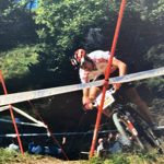 A person racing round a track on a mountain bike.