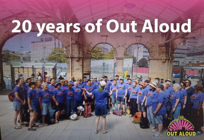 Group photo celebrating 20 years of Out Aloud. A large choir wearing matching blue Out Aloud T-shirts stands in a semicircle beneath a historic indoor market or station canopy. A conductor stands in the centre with their back to the camera. Modern city buildings are visible through the archways in the background. Large text at the top reads “20 years of Out Aloud”. The Out Aloud 20th anniversary logo appears in the bottom-right corner with the dates 2006–2026.